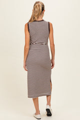 woman wearing a sleeveless brown and white striped maternity dress with a side slit, showing her back
