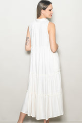 woman wearing a white sleeveless midi dress with a tiered design and relaxed fit, showing the back view
