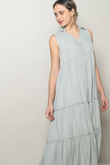 woman wearing a light green sleeveless maxi dress with a button-down collar and tiered ruffle details