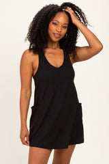 woman wearing a black sleeveless romper with side pockets and a relaxed fit