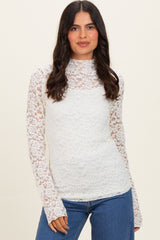 woman wearing a white lace long sleeve top paired with denim jeans