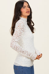 woman wearing a white lace long sleeve top with a high neck and fitted silhouette, paired with blue jeans