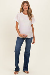 woman wearing a striped short sleeve maternity top and holding her baby bump with blue flared jeans