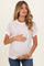 woman wearing a light purple striped maternity top with white trim and holding her baby bump