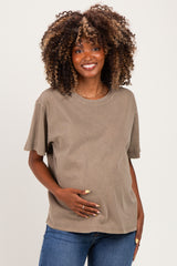 woman wearing a brown oversized maternity t-shirt and holding her baby bump