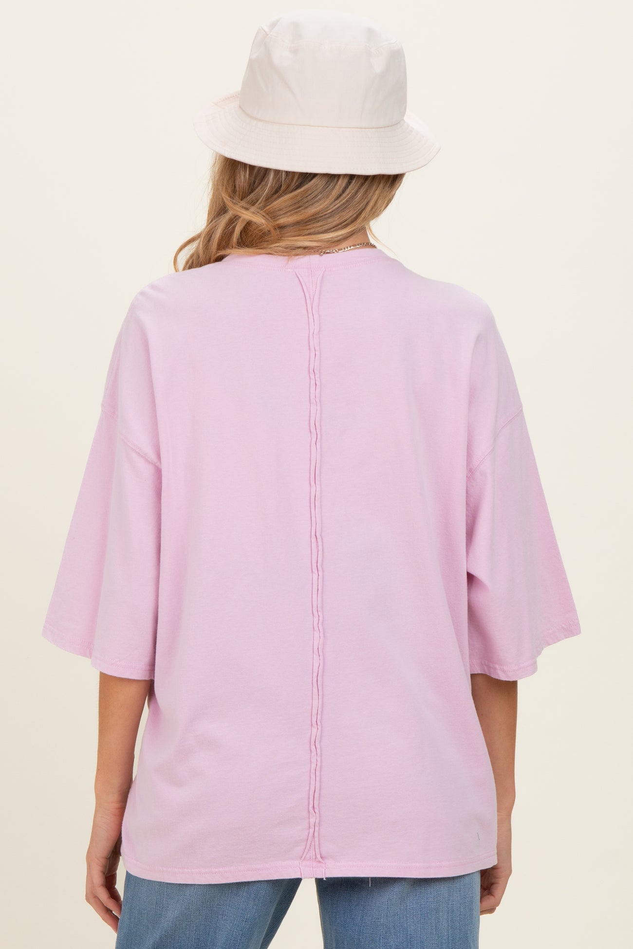 woman wearing a light pink maternity t-shirt with a relaxed fit and braided detail down the back