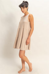 woman wearing a beige tiered tank dress with a relaxed fit and a flared hem