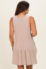 woman wearing a beige sleeveless maternity dress with a tiered design from the back