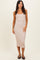woman wearing a nude ribbed midi dress with spaghetti straps and a fitted silhouette