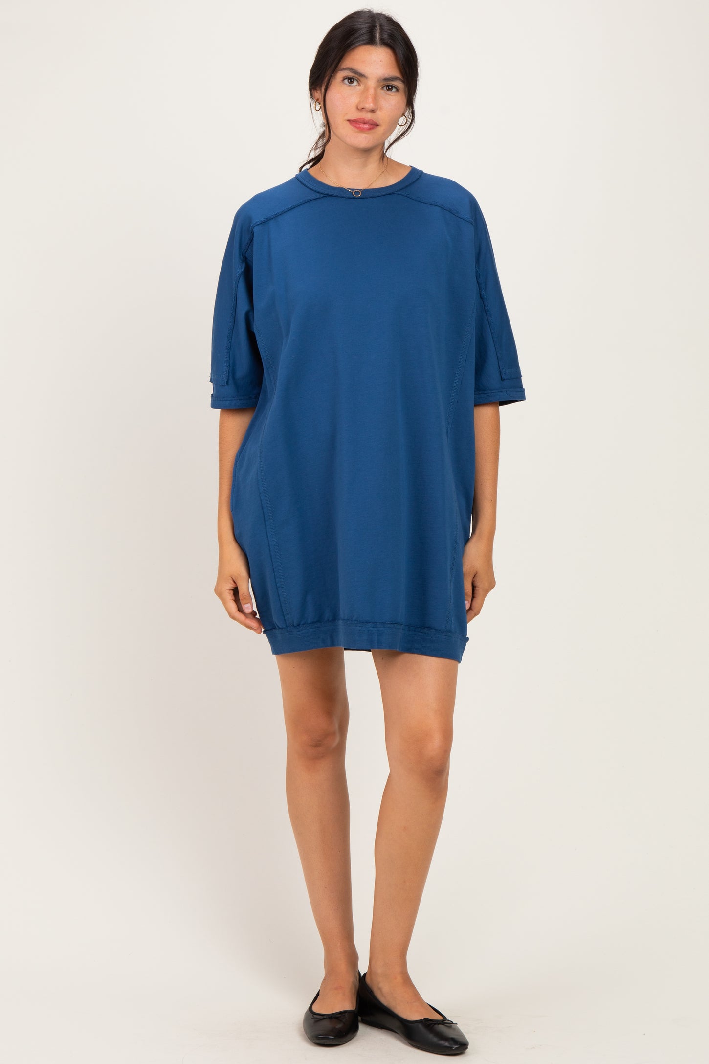 woman wearing a loose-fitting dark blue oversized dress with short sleeves and a rounded neckline