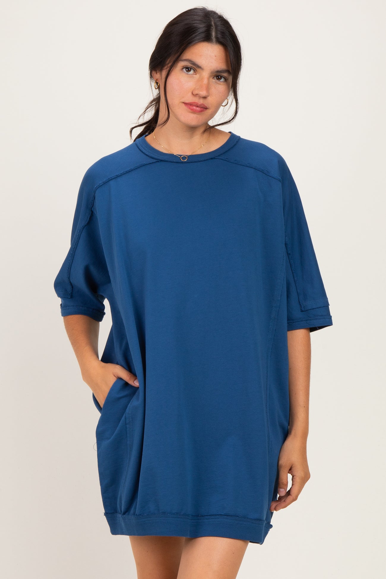 woman wearing a blue oversized t-shirt dress with a round neckline and side pockets