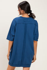 woman wearing a blue oversized t-shirt dress with short sleeves and a relaxed fit from the back