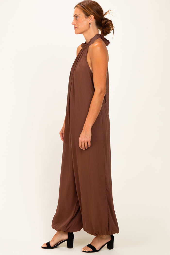 woman wearing a brown halter neck jumpsuit with wide legs and a relaxed fit
