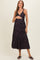 woman wearing a black floral maternity maxi dress and holding her baby bump