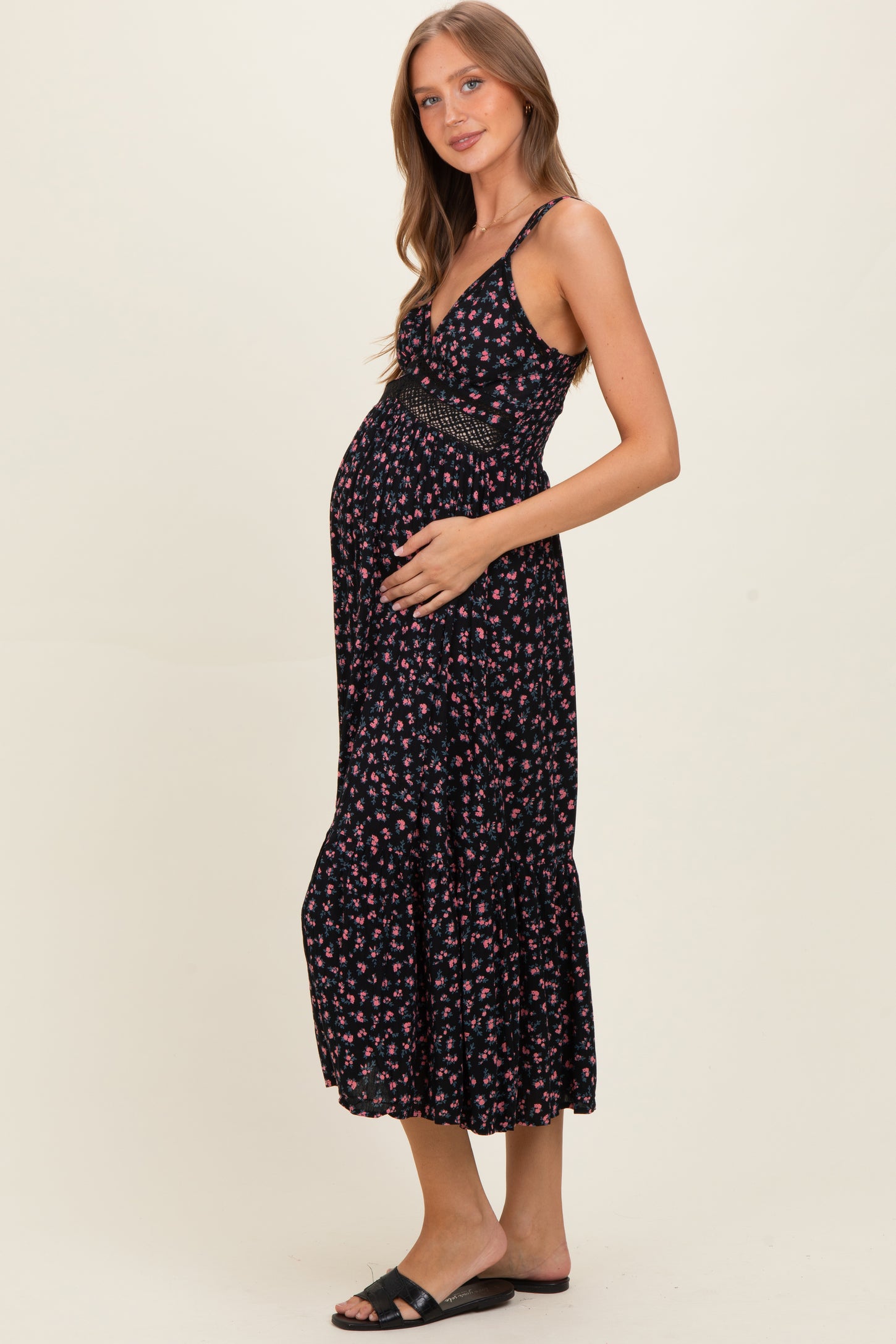woman wearing a navy floral maternity maxi dress and holding her baby bump