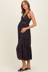 woman wearing a navy floral maternity maxi dress and holding her baby bump