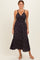 woman wearing a black floral maxi dress with spaghetti straps and a tiered hem
