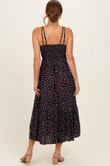 woman wearing a black floral maxi dress with a smocked bodice and adjustable straps, viewed from the back