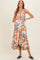 woman wearing a floral maternity maxi dress with a tiered skirt and holding her baby bump
