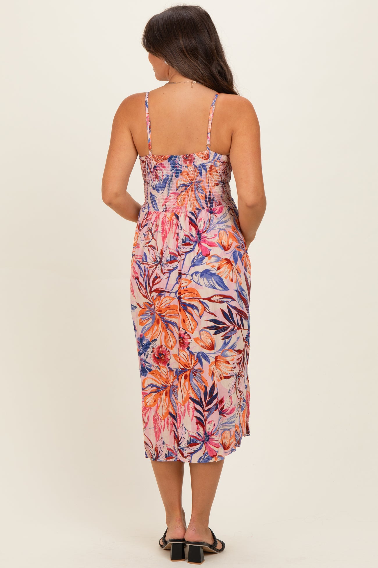 woman wearing a floral print maternity maxi dress with a smocked bodice and spaghetti straps, viewed from the back