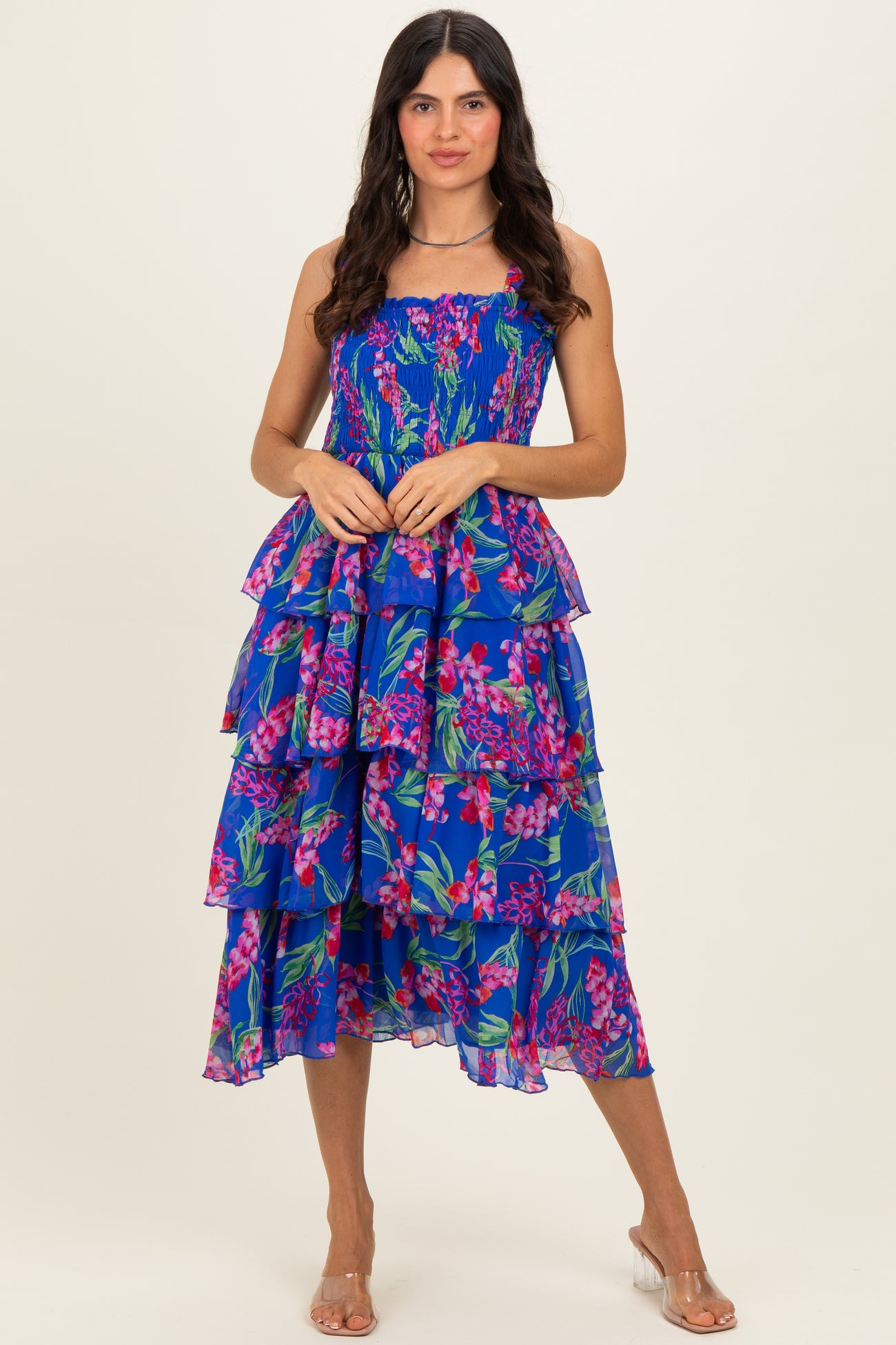 woman wearing a vibrant floral print midi dress with tiered layers and a smocked bodice