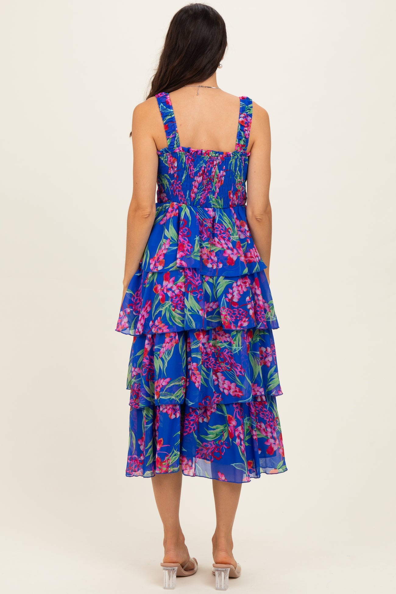 woman wearing a blue floral tiered midi dress with smocked back straps