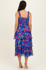 woman wearing a blue floral tiered midi dress with smocked back straps