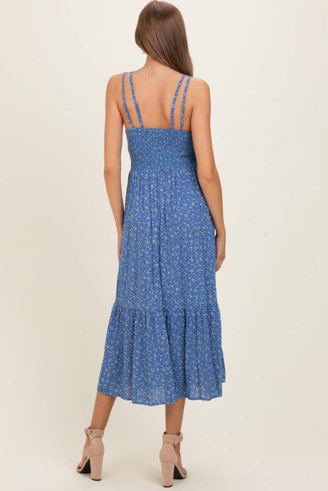 woman wearing a blue floral maternity maxi dress with spaghetti straps and a tiered skirt, showing her back