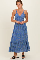 woman wearing a blue floral maxi dress with a fitted bodice and tiered skirt
