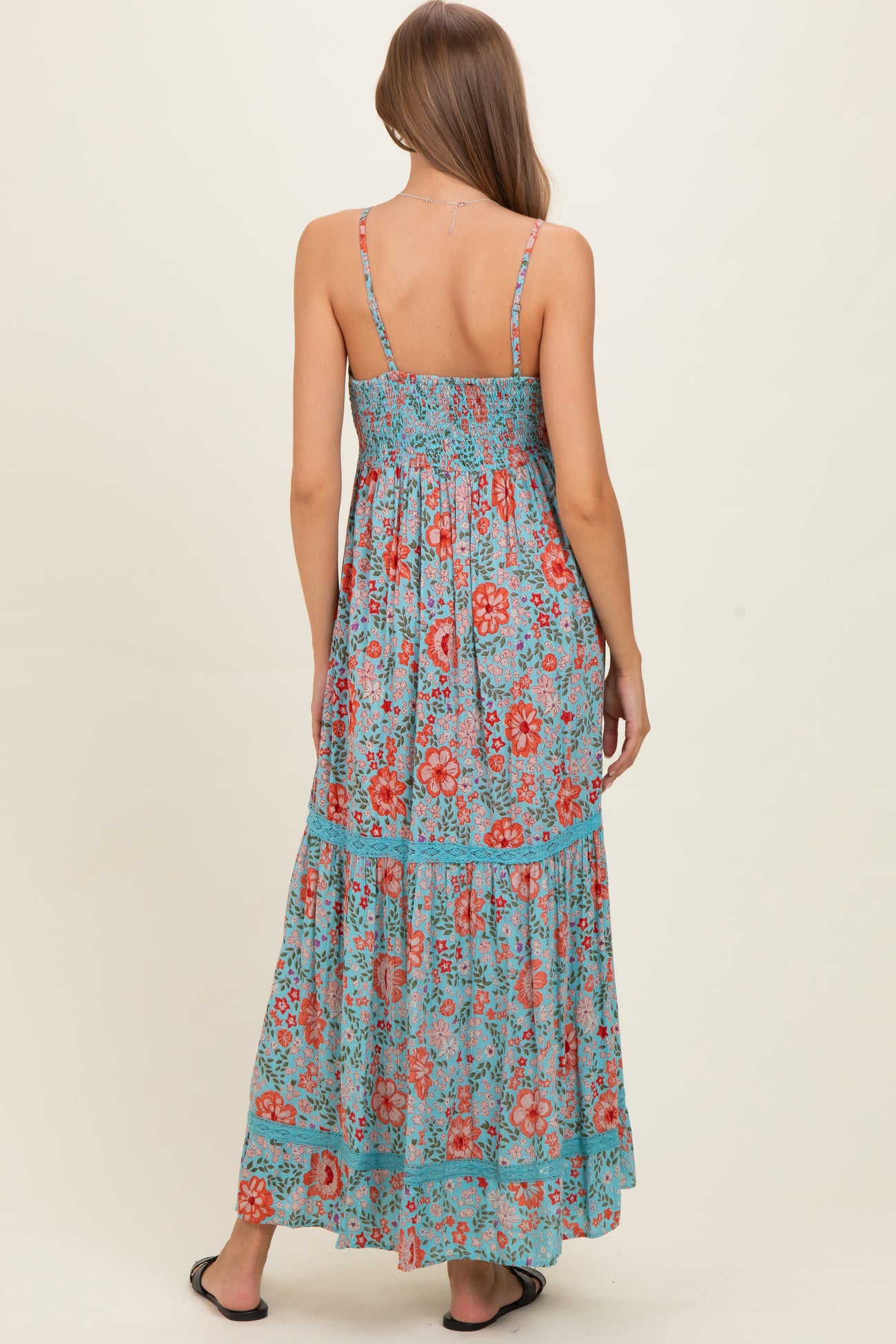 woman wearing a floral print maternity maxi dress with a smocked back and adjustable straps