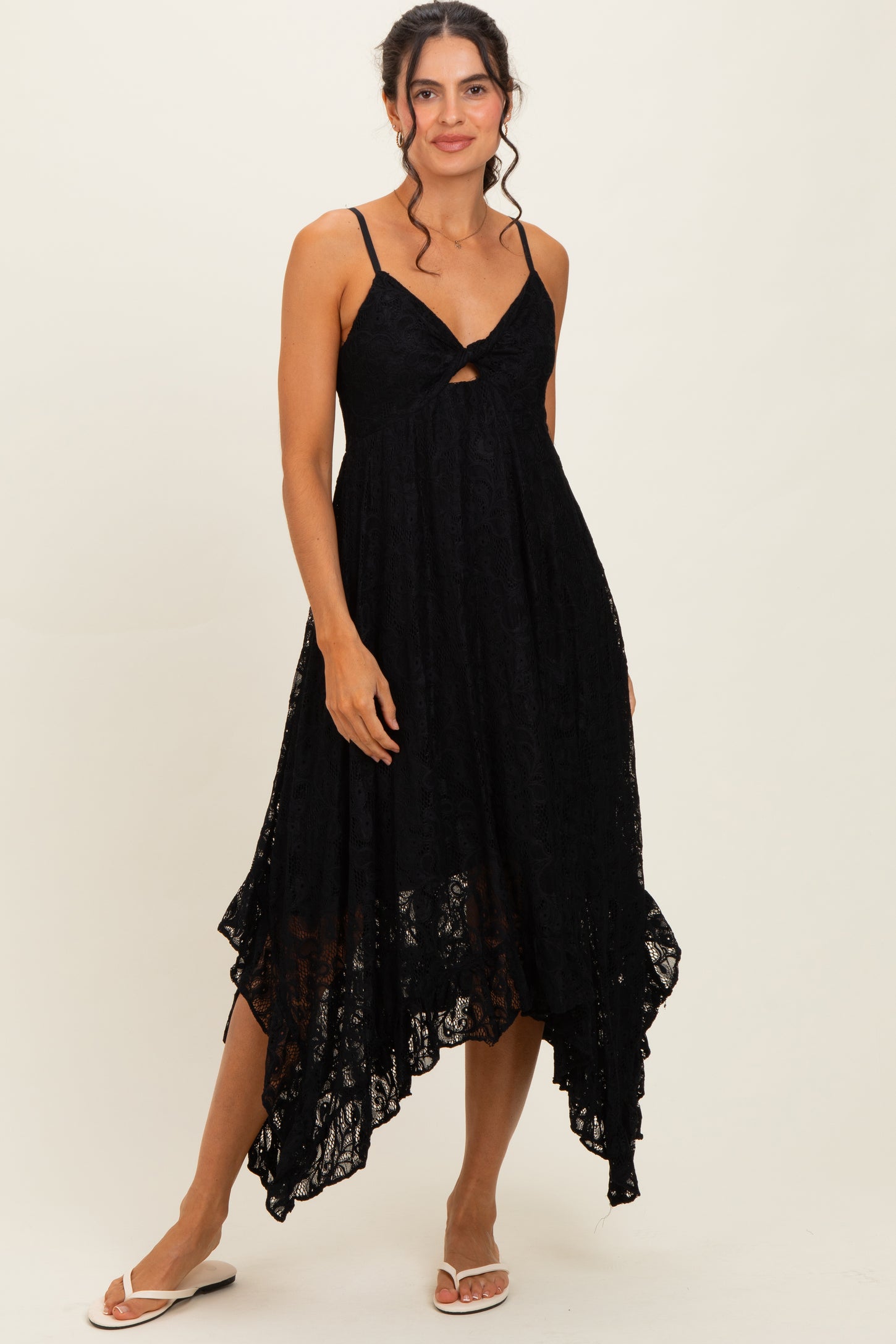 woman wearing a black lace midi dress with spaghetti straps and a high-low hemline