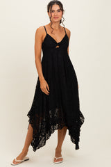 woman wearing a black lace midi dress with spaghetti straps and a high-low hemline
