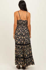 woman wearing a black floral maxi dress with a smocked bodice and tiered skirt, shown from the back
