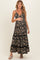 woman wearing a black floral maternity maxi dress with adjustable straps and tiered skirt, showing her baby bump