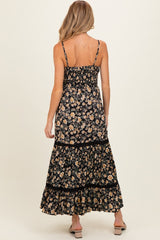 woman wearing a black floral maternity maxi dress with a smocked bodice and tiered skirt, showing her back