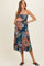 woman wearing a floral strapless maternity dress and gently holding her baby bump