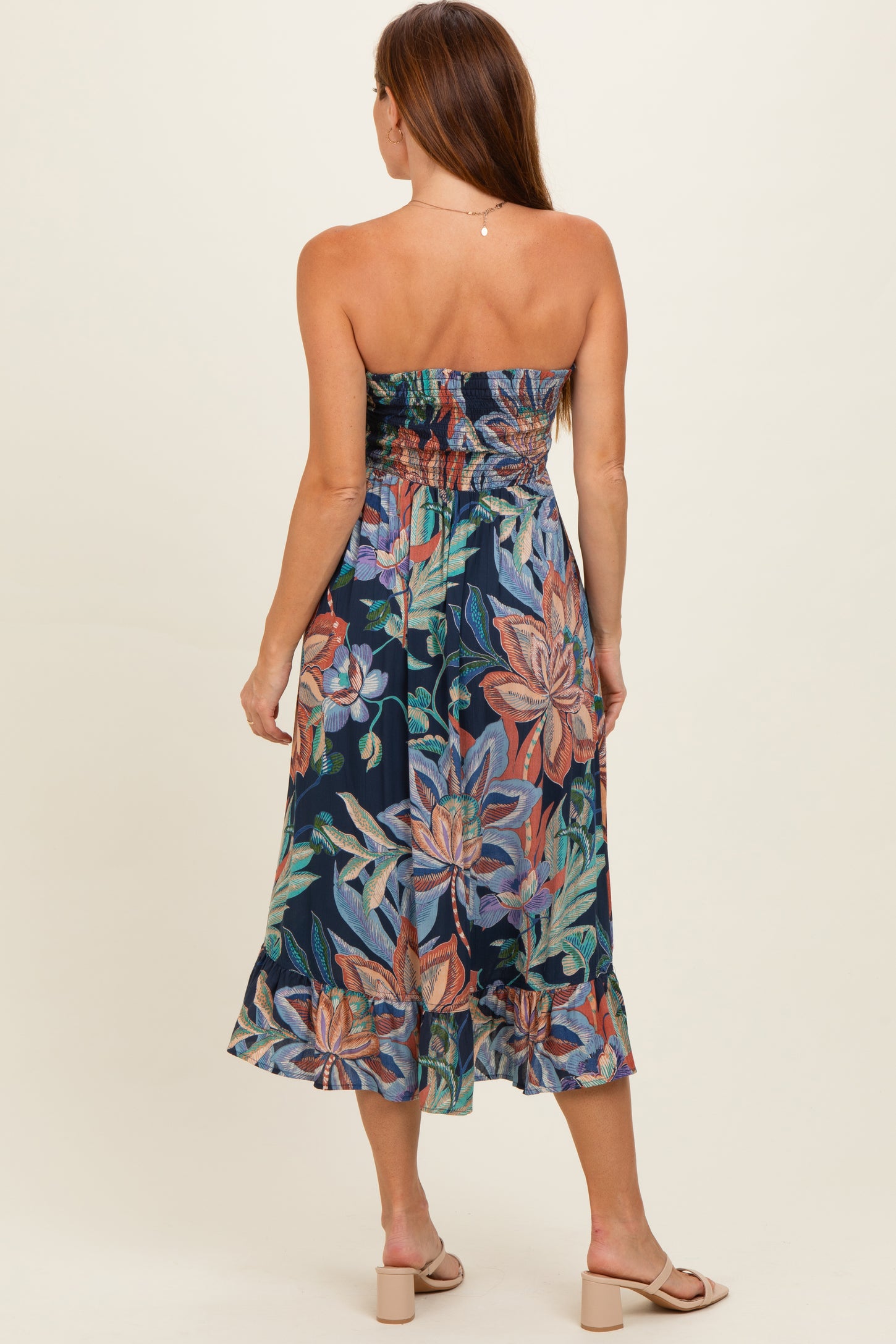 woman wearing a strapless floral midi dress with a fitted bodice and a flared skirt, viewed from the back