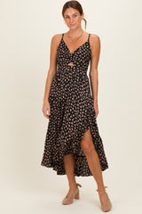 woman wearing a black floral midi dress with a front cutout and side slit, paired with nude heels