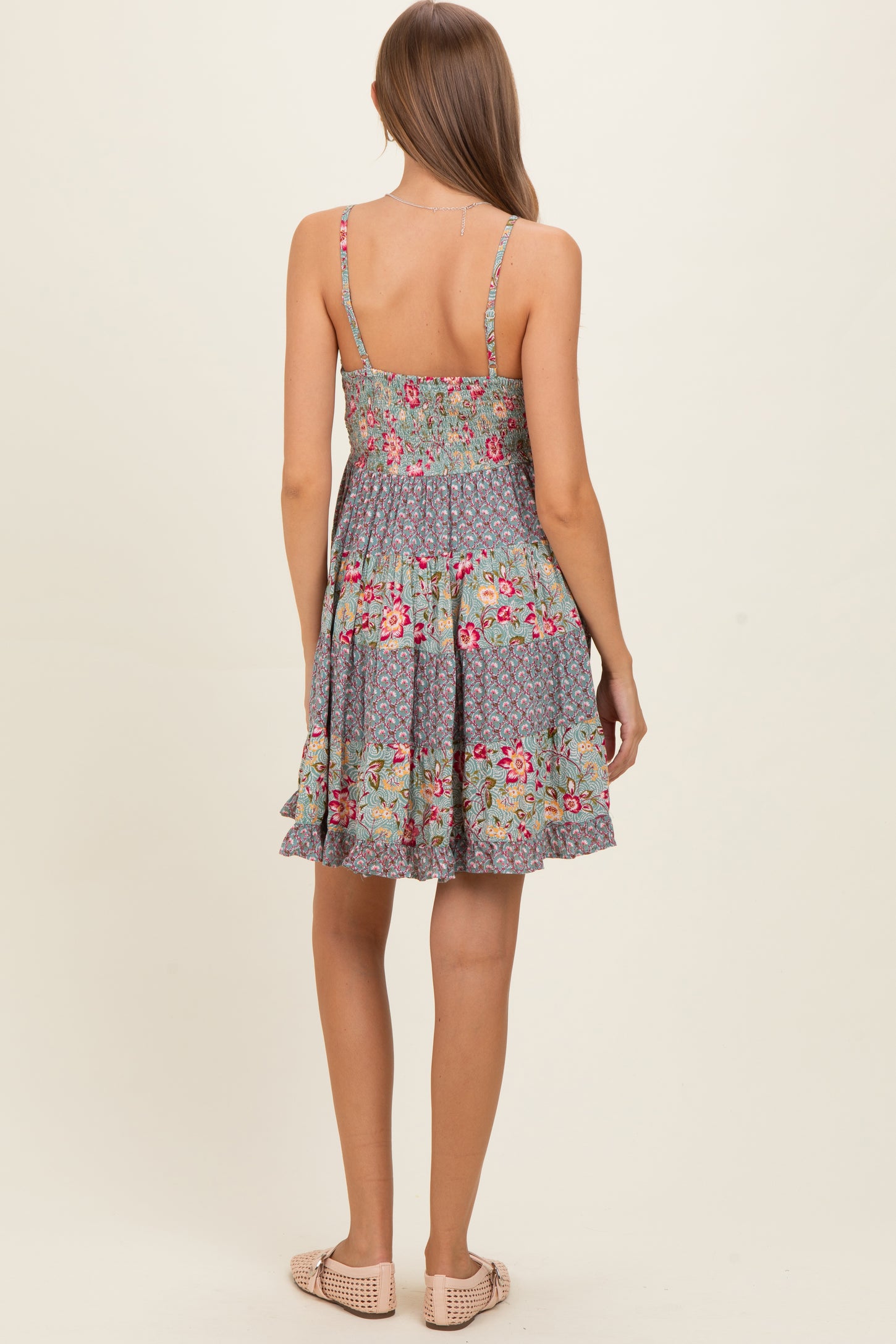 woman wearing a floral grey maternity dress with spaghetti straps and a flared skirt