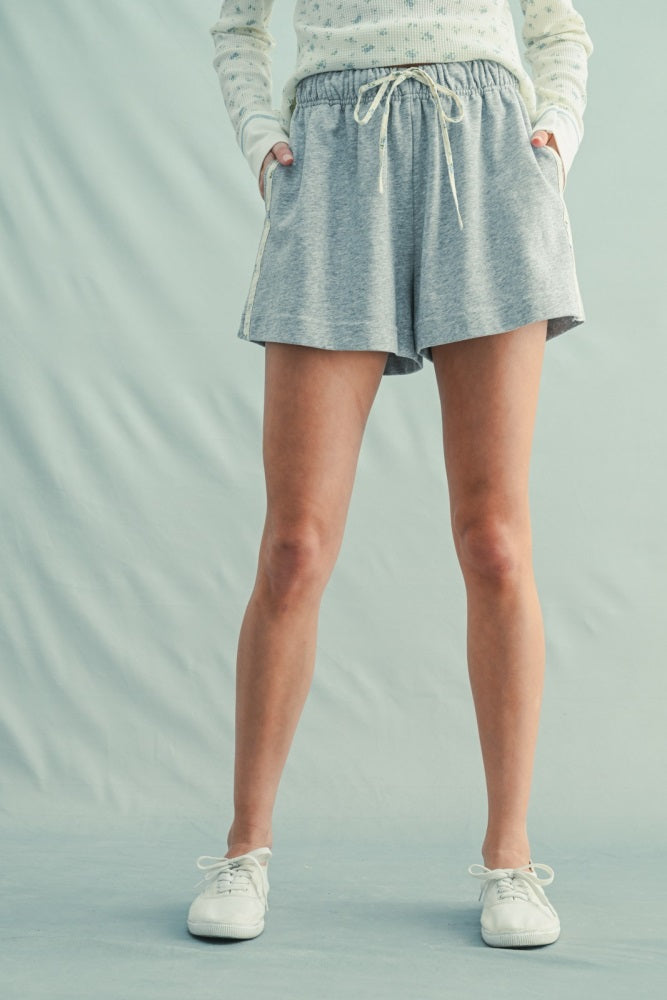 woman wearing gray drawstring shorts with side pockets and a relaxed fit