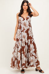 woman wearing a brown floral maxi dress with a tiered skirt and adjustable straps