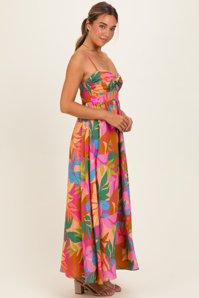 woman wearing a colorful floral print maxi dress with a fitted bodice and spaghetti straps