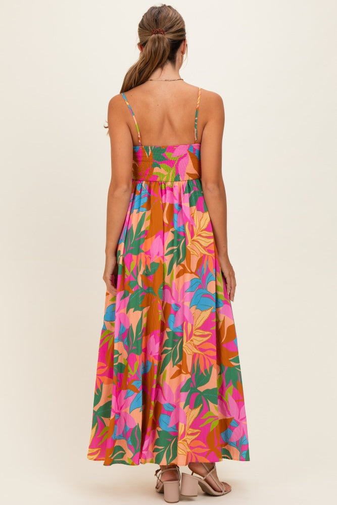 woman wearing a colorful floral maxi dress with a smocked bodice and adjustable straps, shown from the back