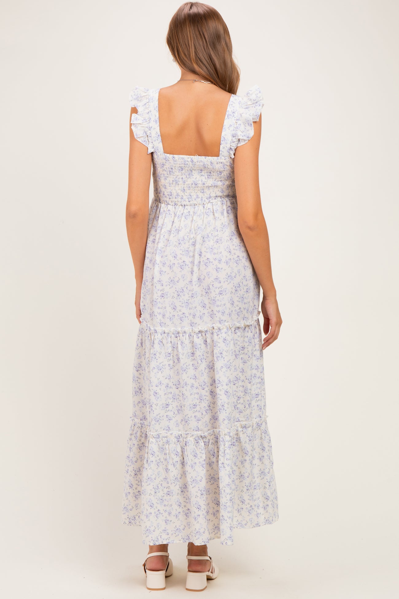 woman wearing a lavender floral maternity maxi dress with ruffled sleeves and square back detail