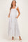 woman wearing a white floral maternity maxi dress with ruffle straps and pockets, showcasing her baby bump