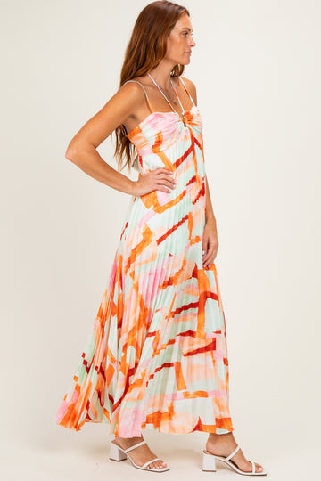 woman wearing a colorful pleated maxi dress with a strapless design and abstract print