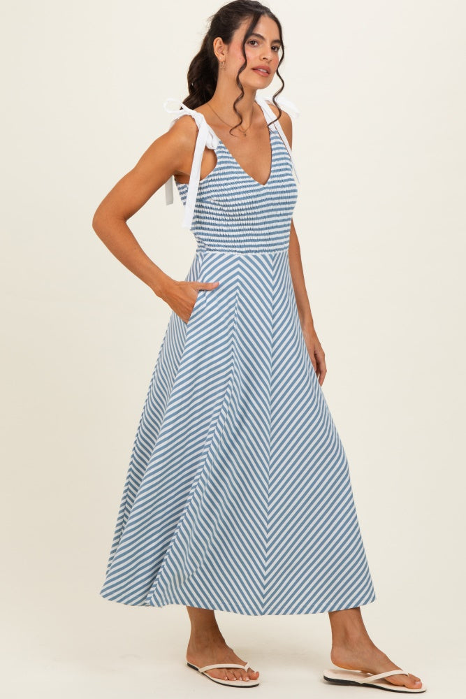 woman wearing a blue and white striped maxi dress with tie straps and pockets