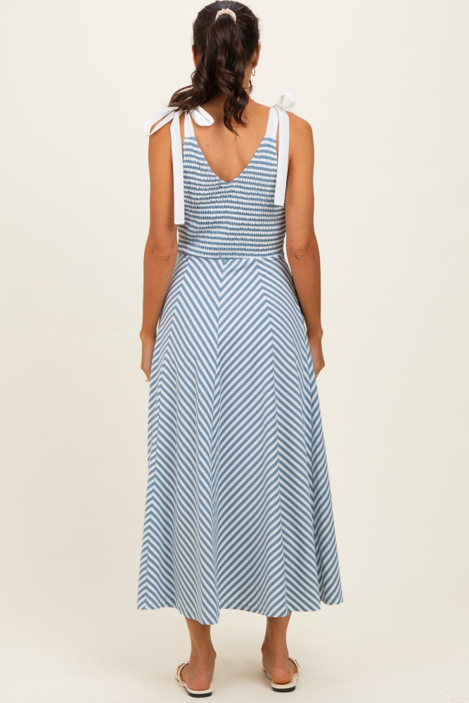woman wearing a back view of a blue and white striped maxi dress with tie shoulder straps and a fitted bodice