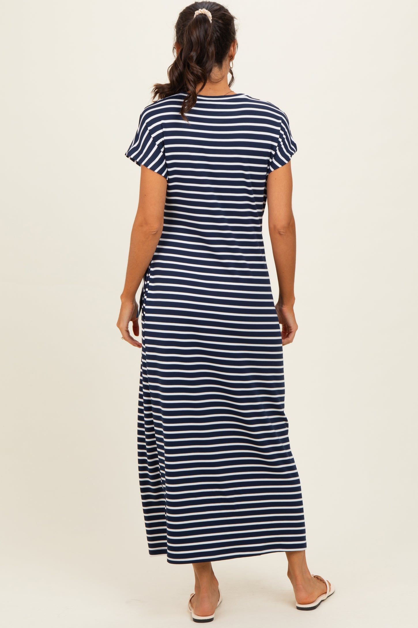 woman wearing a navy and white striped maxi dress with short sleeves, shown from the back