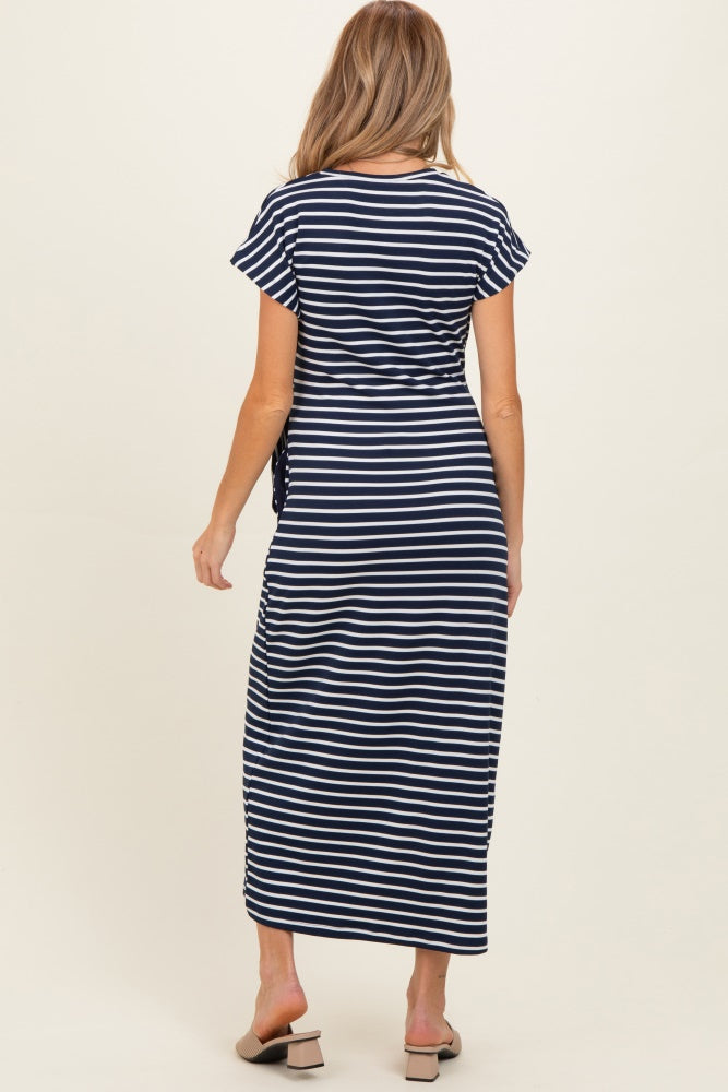 woman wearing a navy and white striped maternity maxi dress with short sleeves and a tie detail at the waist